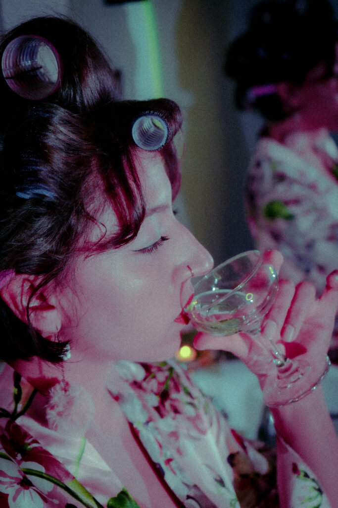 closeup of a woman in a retro silk robe, with a nose ring and curlers in her hair